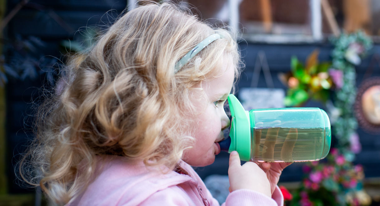 Young gril drinking from green sportee water bottle