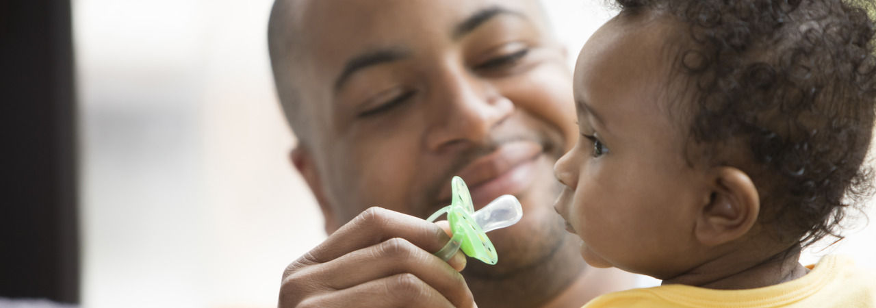 Father holding Fun style soother 