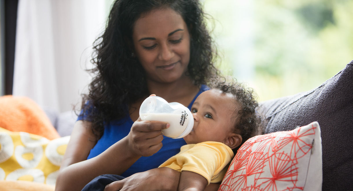 Mother feeding baby milk with closer to nature bottle