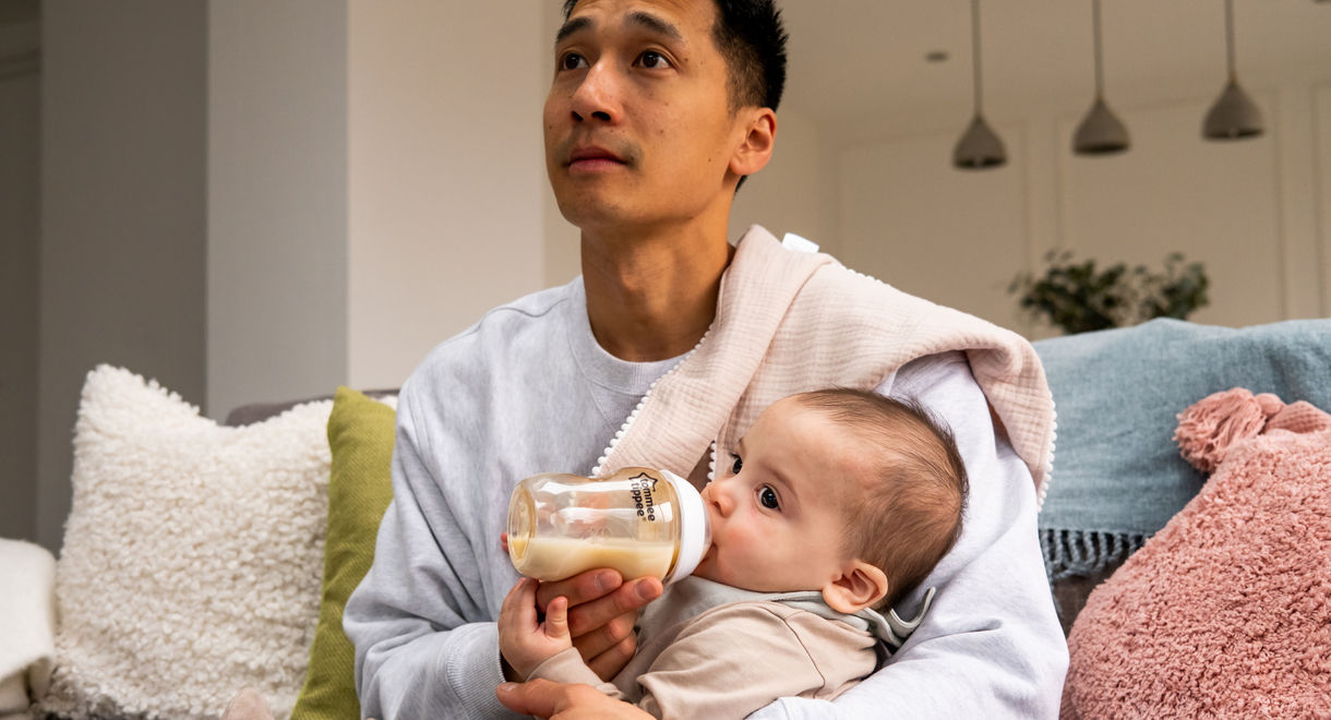 Père tenant bébé sur son genou nourrissant lait de bébé d'un biberon Closer to nature PPSU