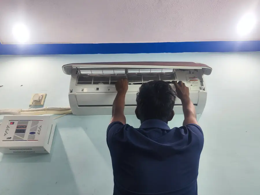 Our technician removing the AC indoor unit filter for cleaning