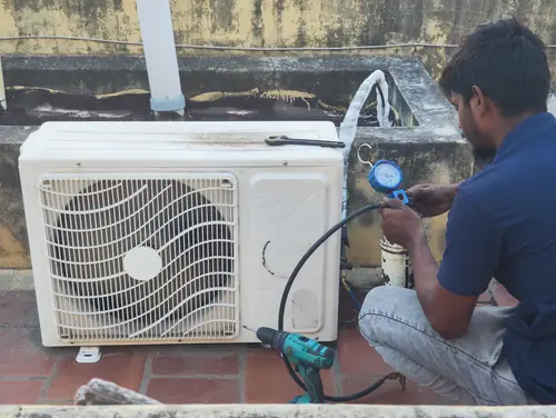 Our expert technician performing precise AC gas recharge, restoring optimal cooling performance and efficiency for your air conditioner in Madurai.