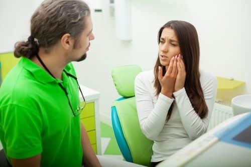 Patient explaining to doctor about dental pain Patient explaining to doctor about dental pain