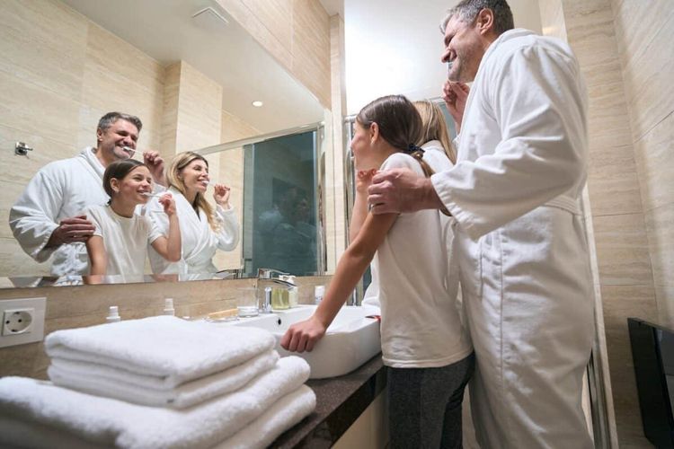 Family of three enjoys dental hygiene together in bathroom