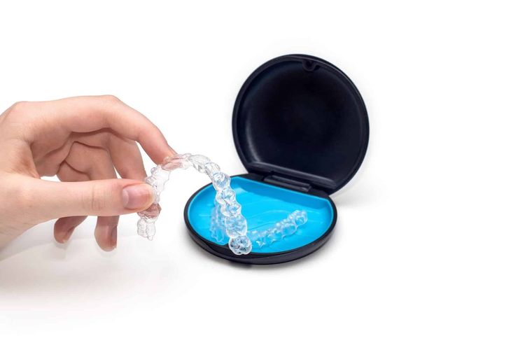 Teeth aligners in a storage case. Invisible braces. Clear teeth straighteners. Clear plastic braces