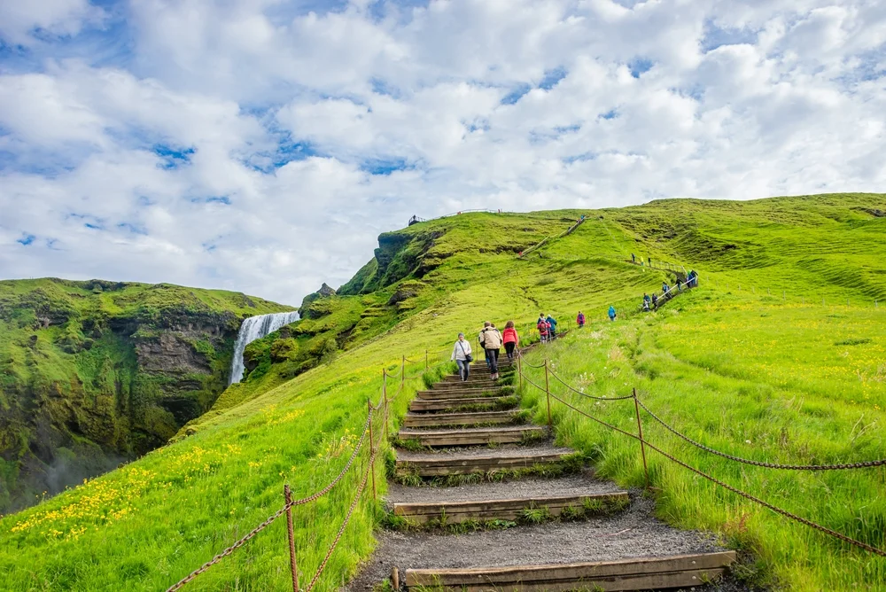 Hike the stairs to the top of Skógafoss