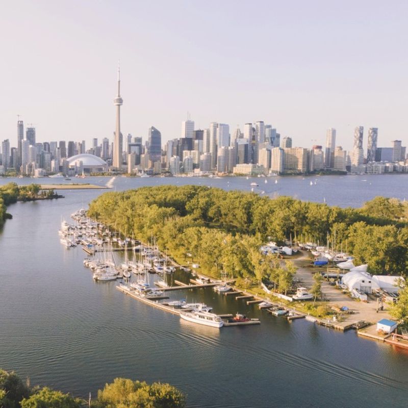 Uitzicht op de haven van Toronto, met skyscrapers, bootjes en parken.