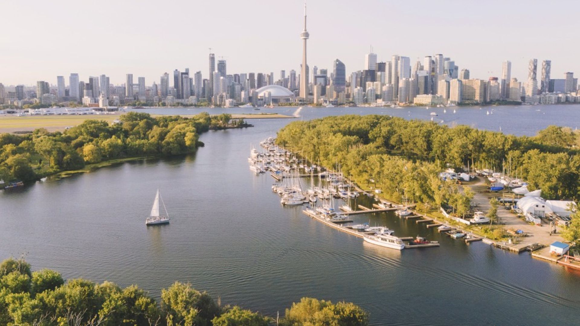 Uitzicht op de haven van Toronto, met skyscrapers, bootjes en parken.