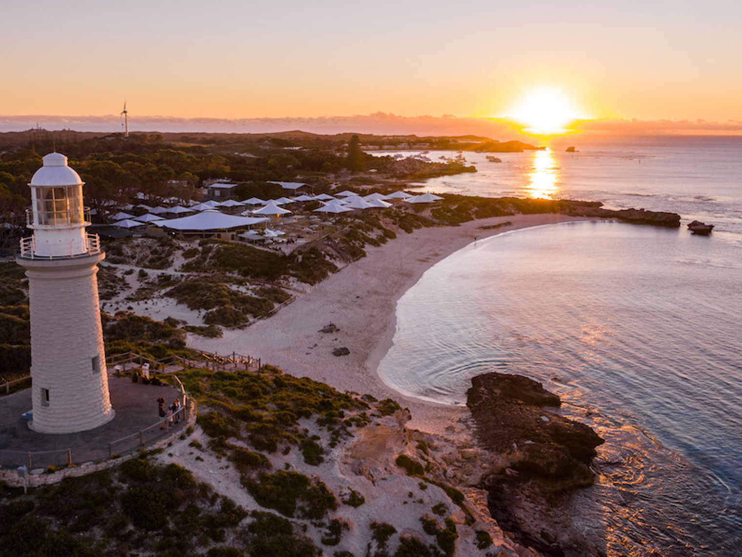 Ein Leuchtturm an der Küste mit einem Sonnenuntergang im Hintergrund