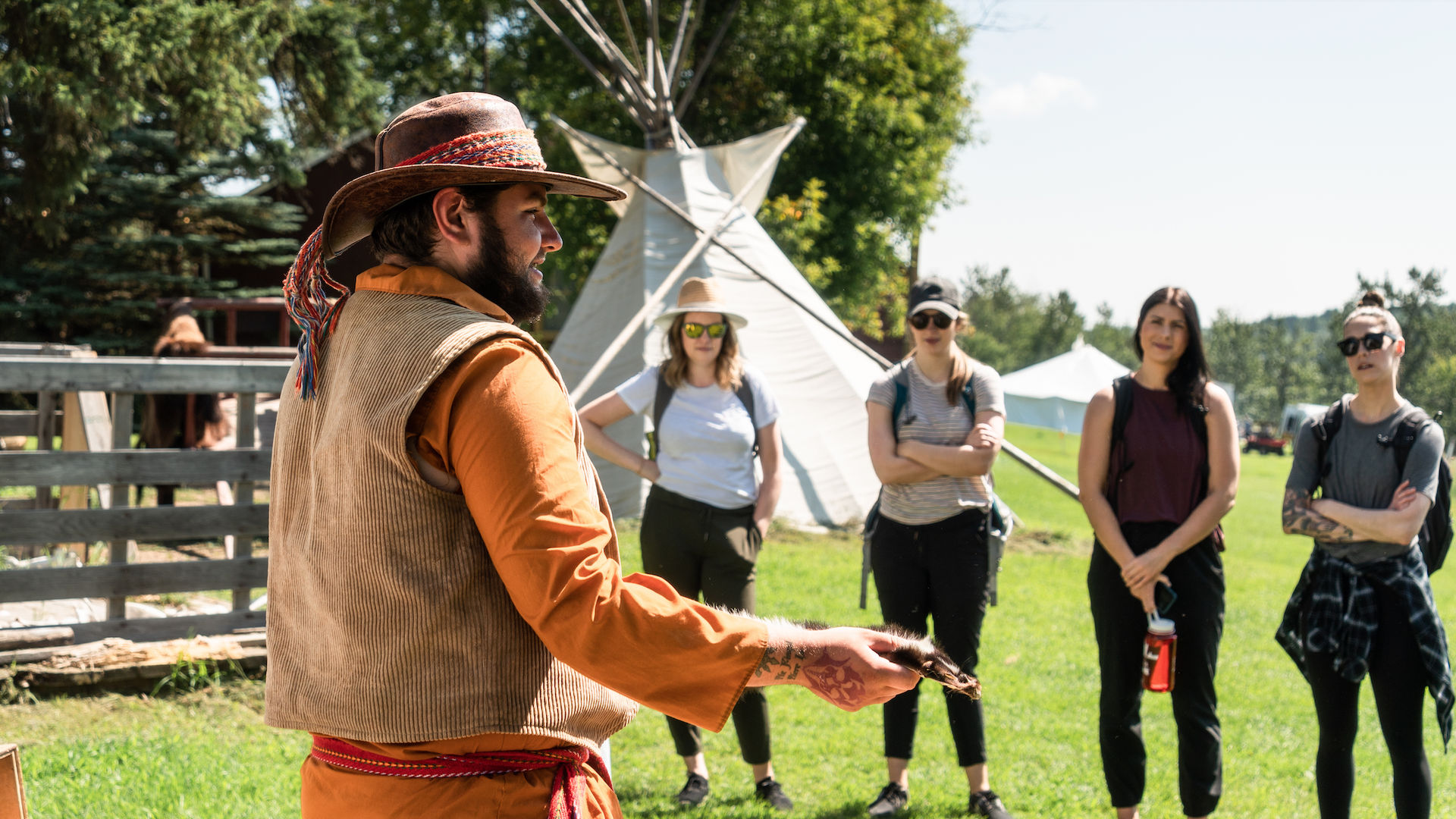 An Indigenous Metis guide giving a talk to a group of tourists in Alberta, Canada
