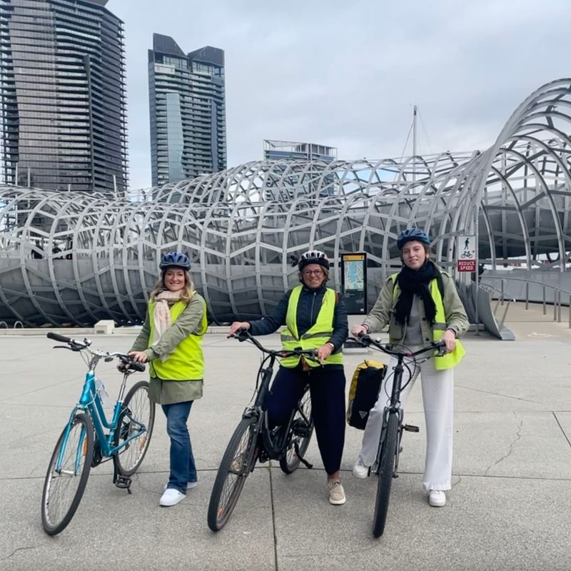 Drie vrouwen poseren met hun fiets in Melbourne