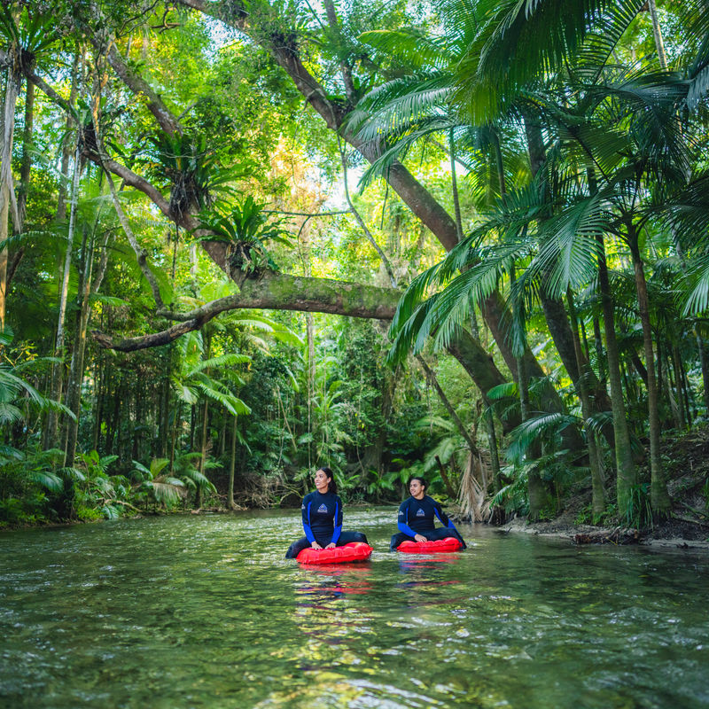 Twee mensen drijven een rivier af omringd door de jungle