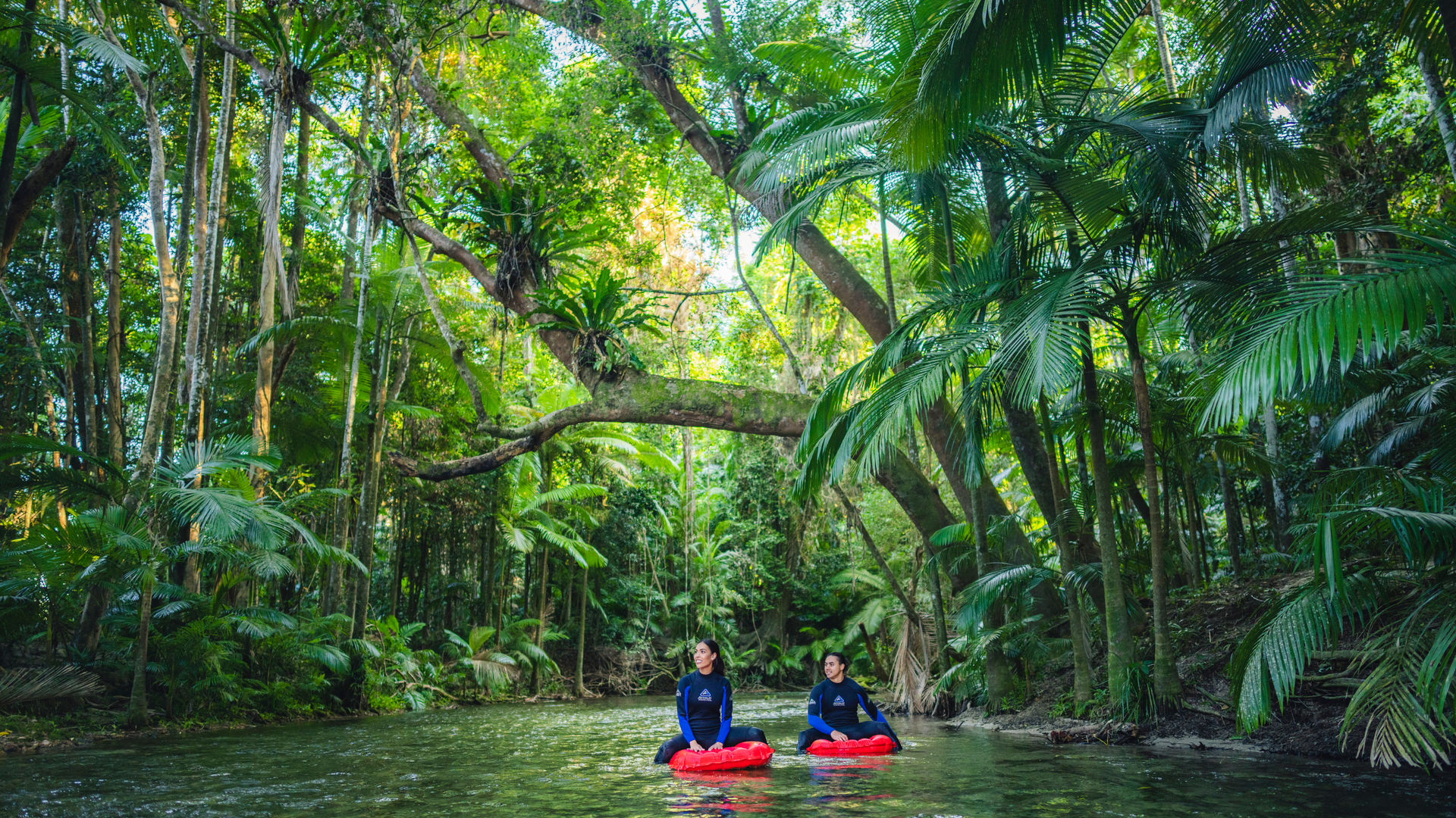 Twee mensen drijven een rivier af omringd door de jungle