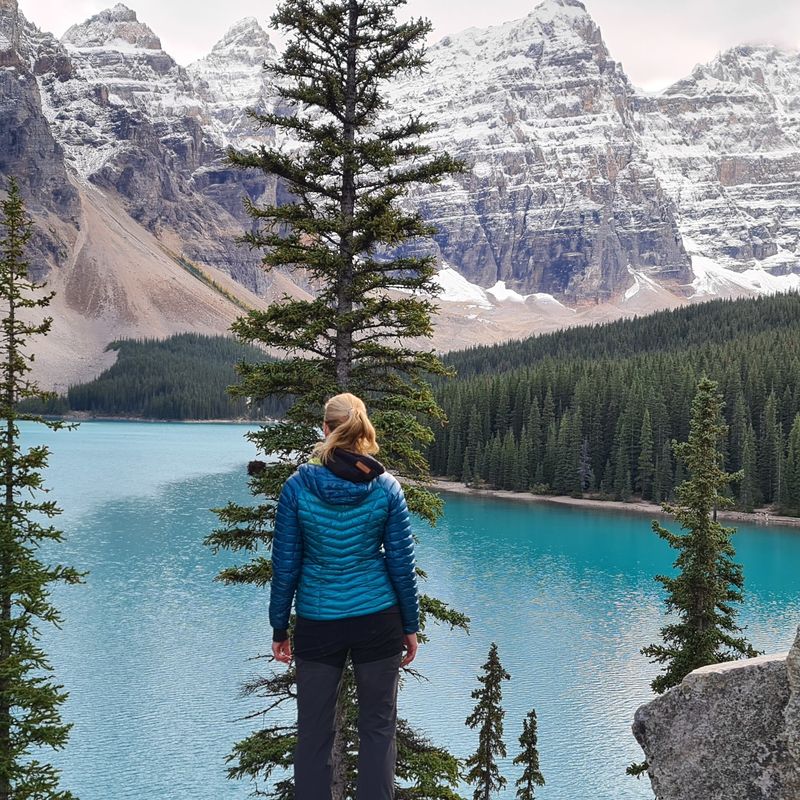 Vrouw staat bij een meer en bergen in Canada