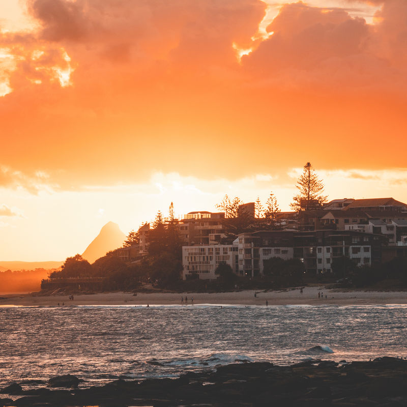 Zee en huizen aan de kust tegen een lucht met een kleurrijke zonsondergang in Australië