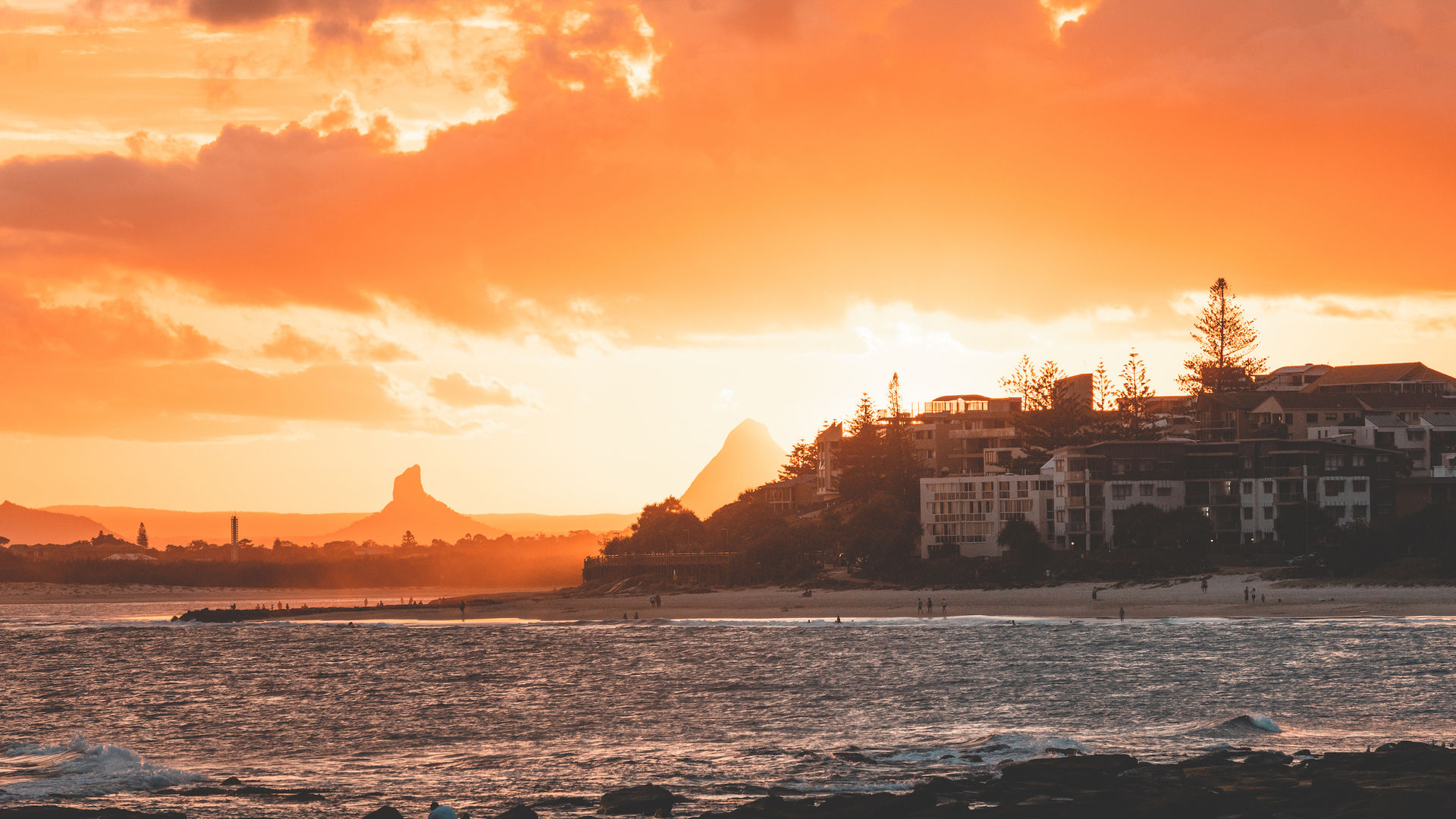 Zee en huizen aan de kust tegen een lucht met een kleurrijke zonsondergang in Australië