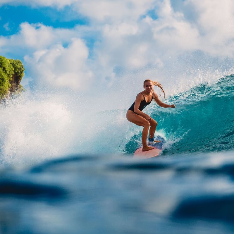 Een vrouw surft in Tahiti