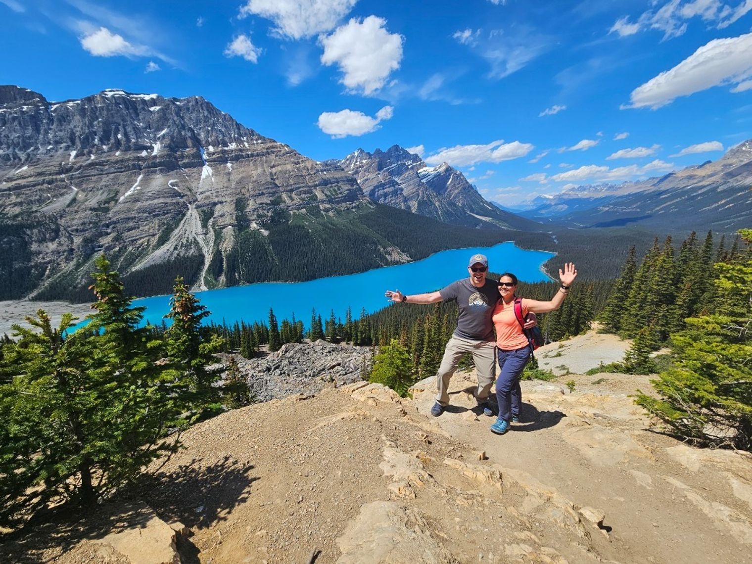 A couple posing for a picture with Peyto Lake in the background, Icefields Parkway