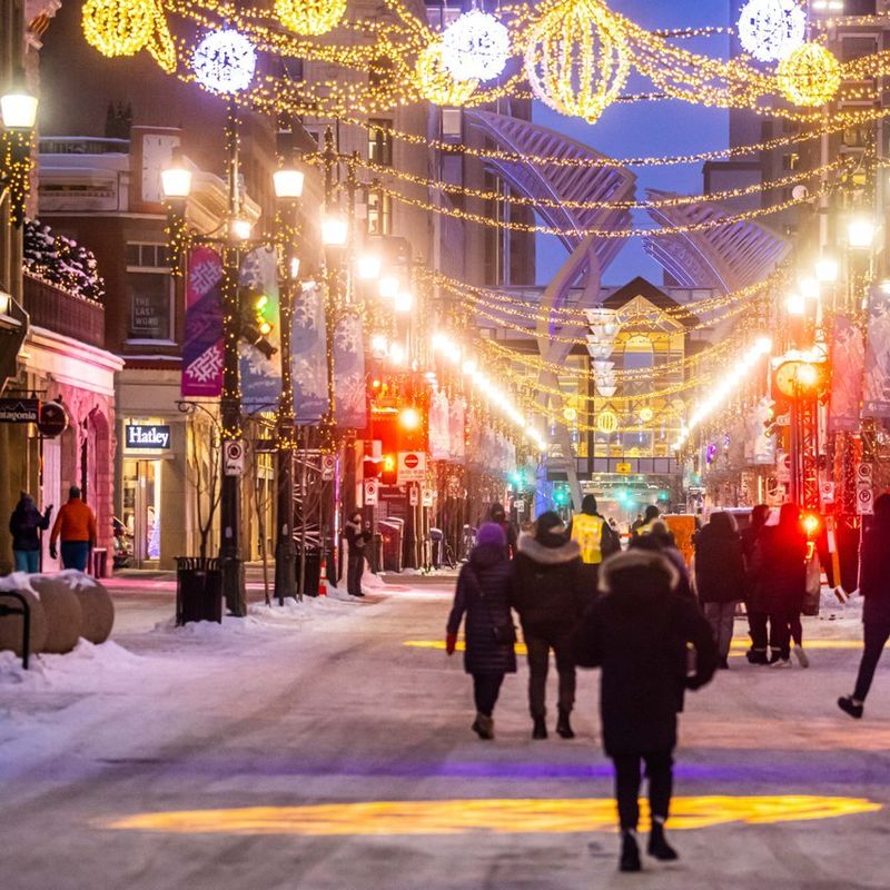 Winters straatbeeld in Calgary met gezellige slingers van lichtjes boven de straat
