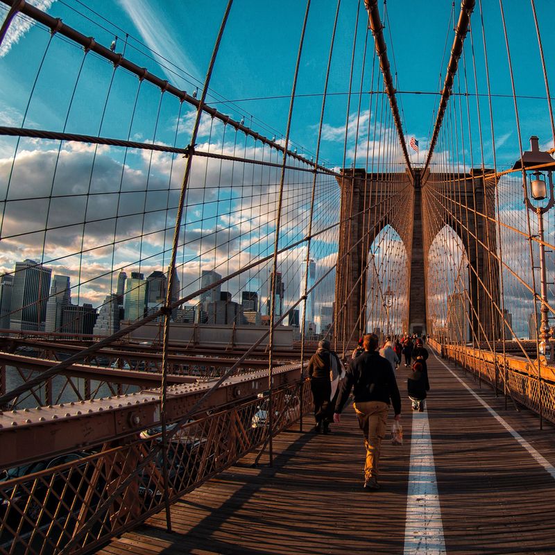 Pedestrians walk across Brooklyn Bridge in New York City