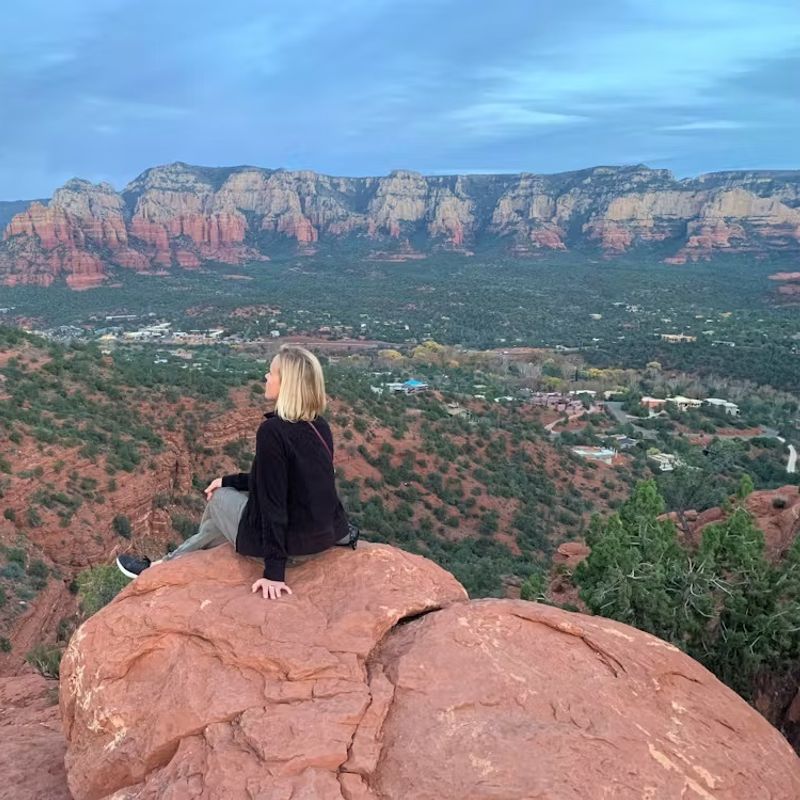Vrouw op rots met uitzicht op de Grand Canyon