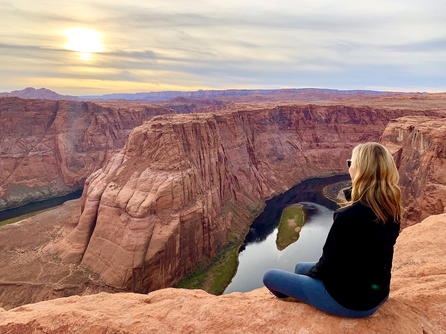 Frau blickt von Aussichtspunkt auf den Horseshoe Bend, die Flussschleife des Colorado Rivers