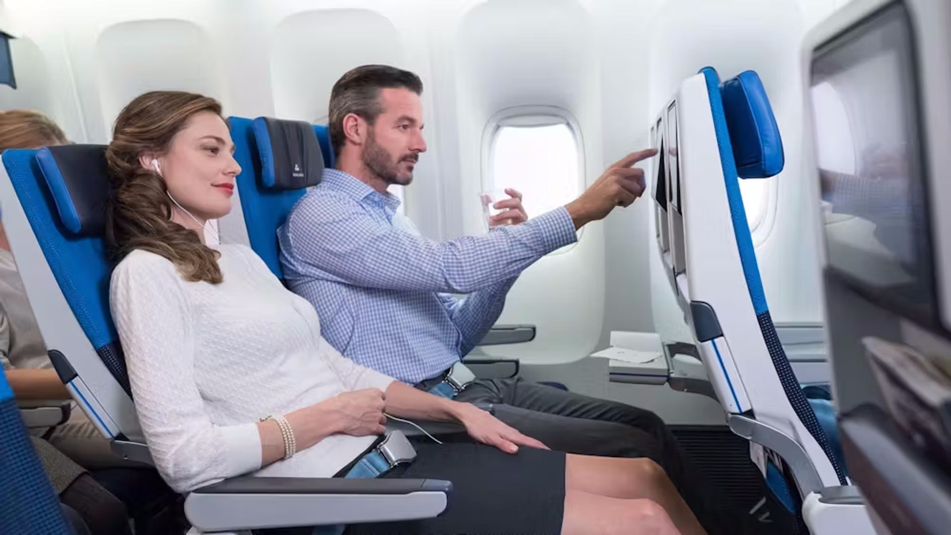 Zwei Personen genießen das Unterhaltungssystem an Bord in der Premium Economy