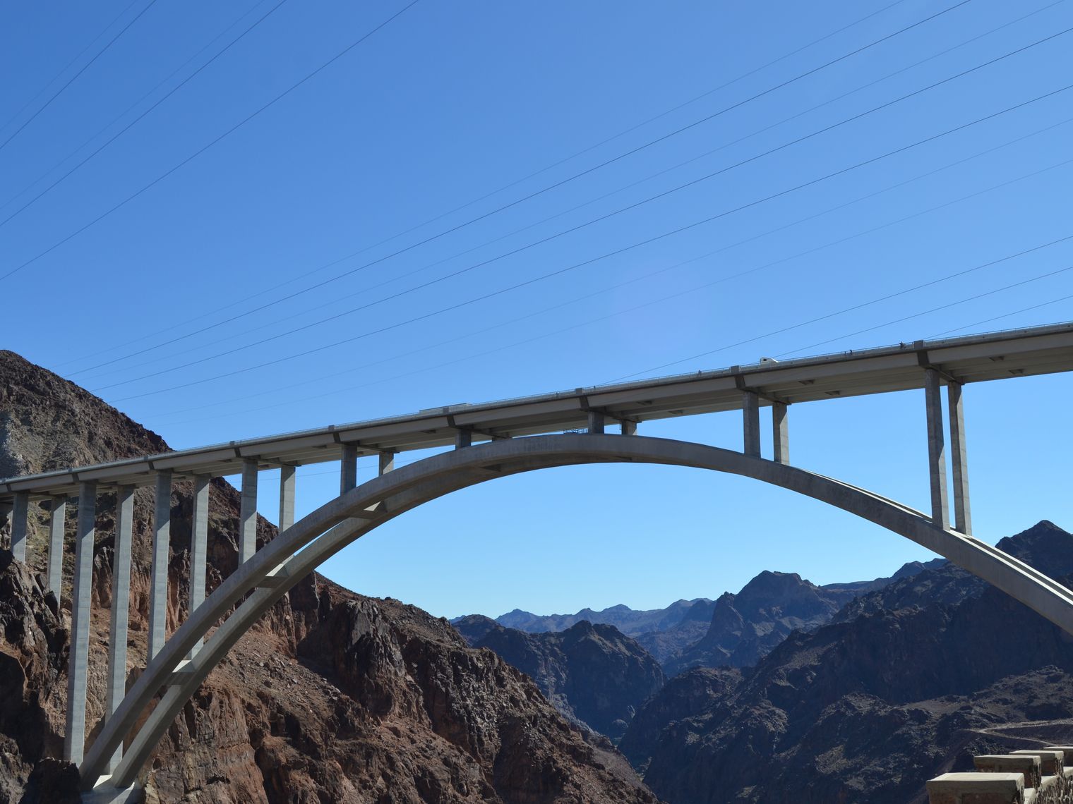An image of the hoover dam bridge with mountains in the background