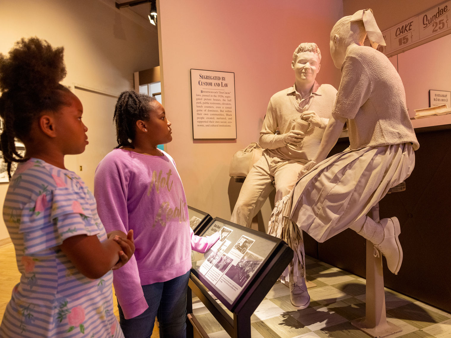 Zwei Mädchen betrachten Statue in Museum in Alabama