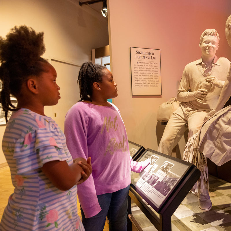 Zwei Mädchen betrachten Statue in Museum in Alabama