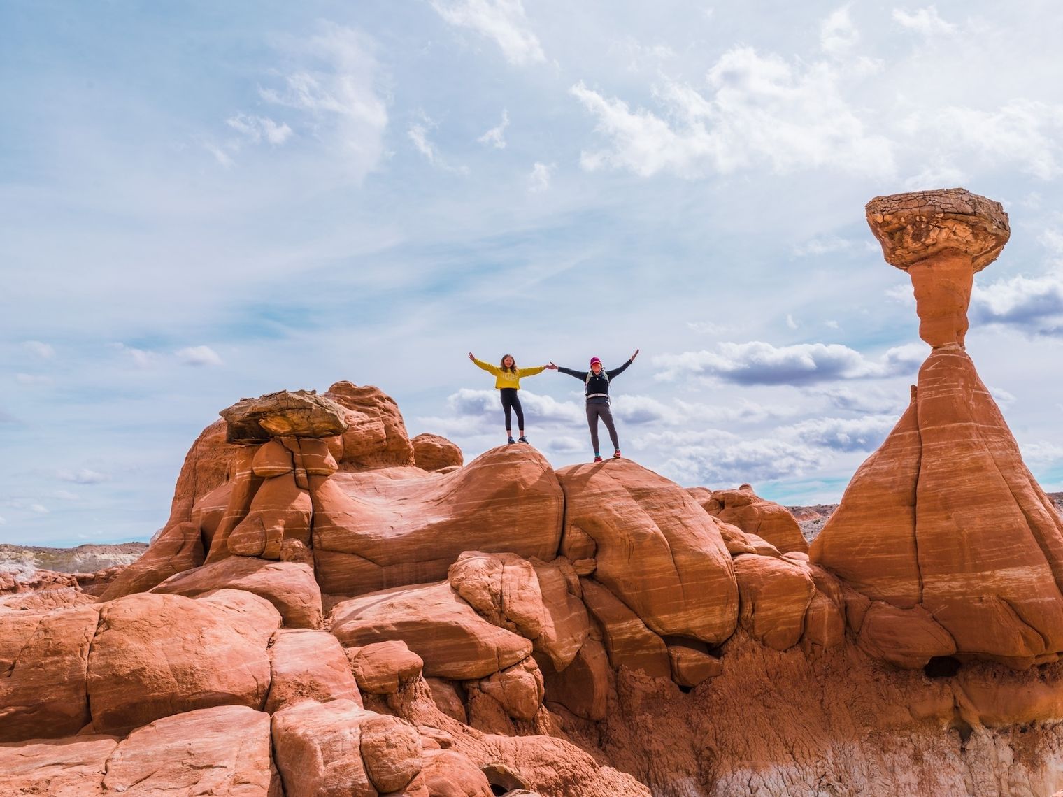 Twee mensen houden hun armen in de arm terwijl ze bovenop rotsen staan in Kanab, Utah