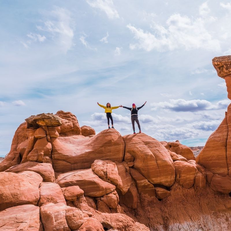 Twee mensen houden hun armen in de arm terwijl ze bovenop rotsen staan in Kanab, Utah