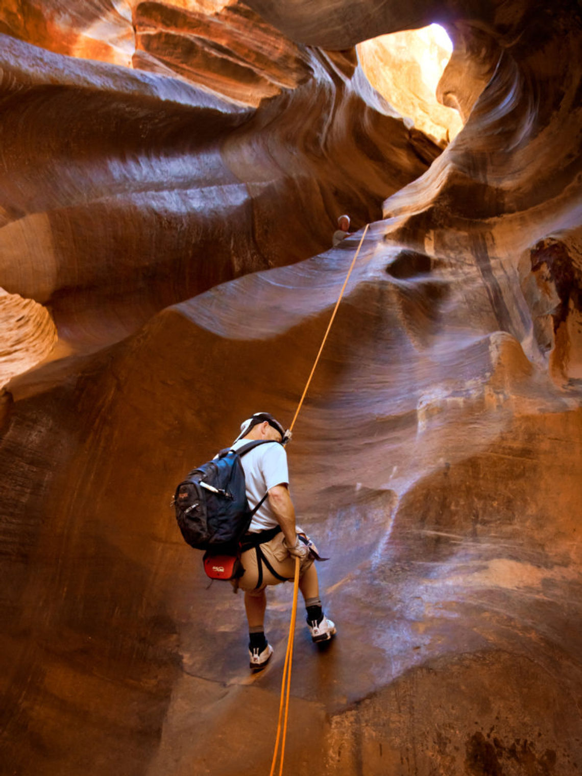 Mann seilt sich in rotem Slotcanyon nach unten in Utah