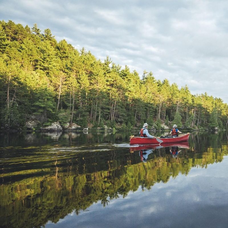 Twee mensen varend in een kano over het water in Algonquin Provincial Park