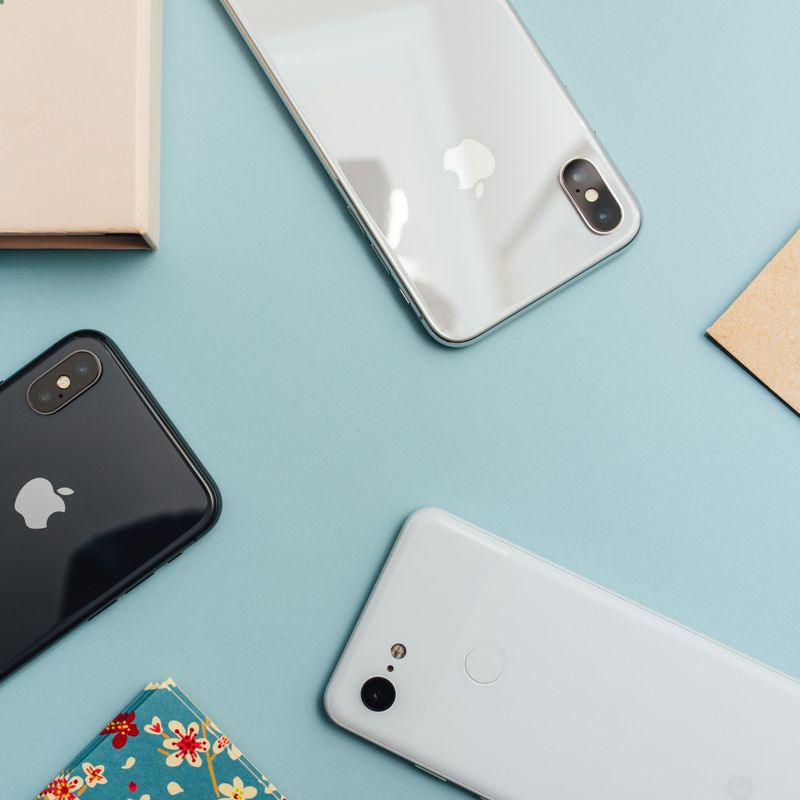 Telefone liegen auf einem hellblauen Untergrund