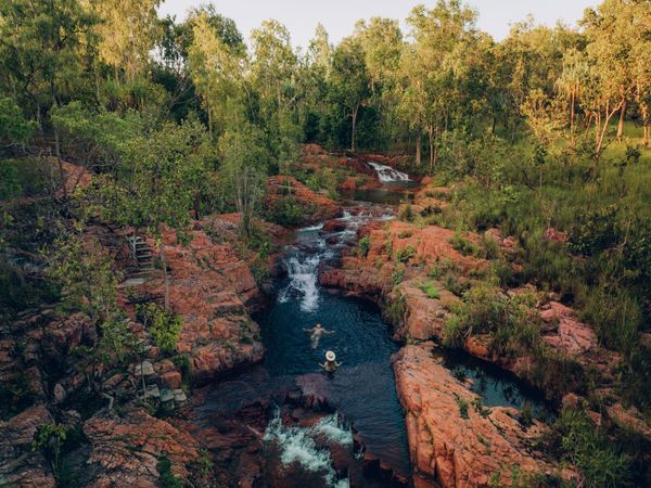 Menschen, die in einem kleinen Bach im Litchfield-Nationalpark bei Buley Rock schwimmen.