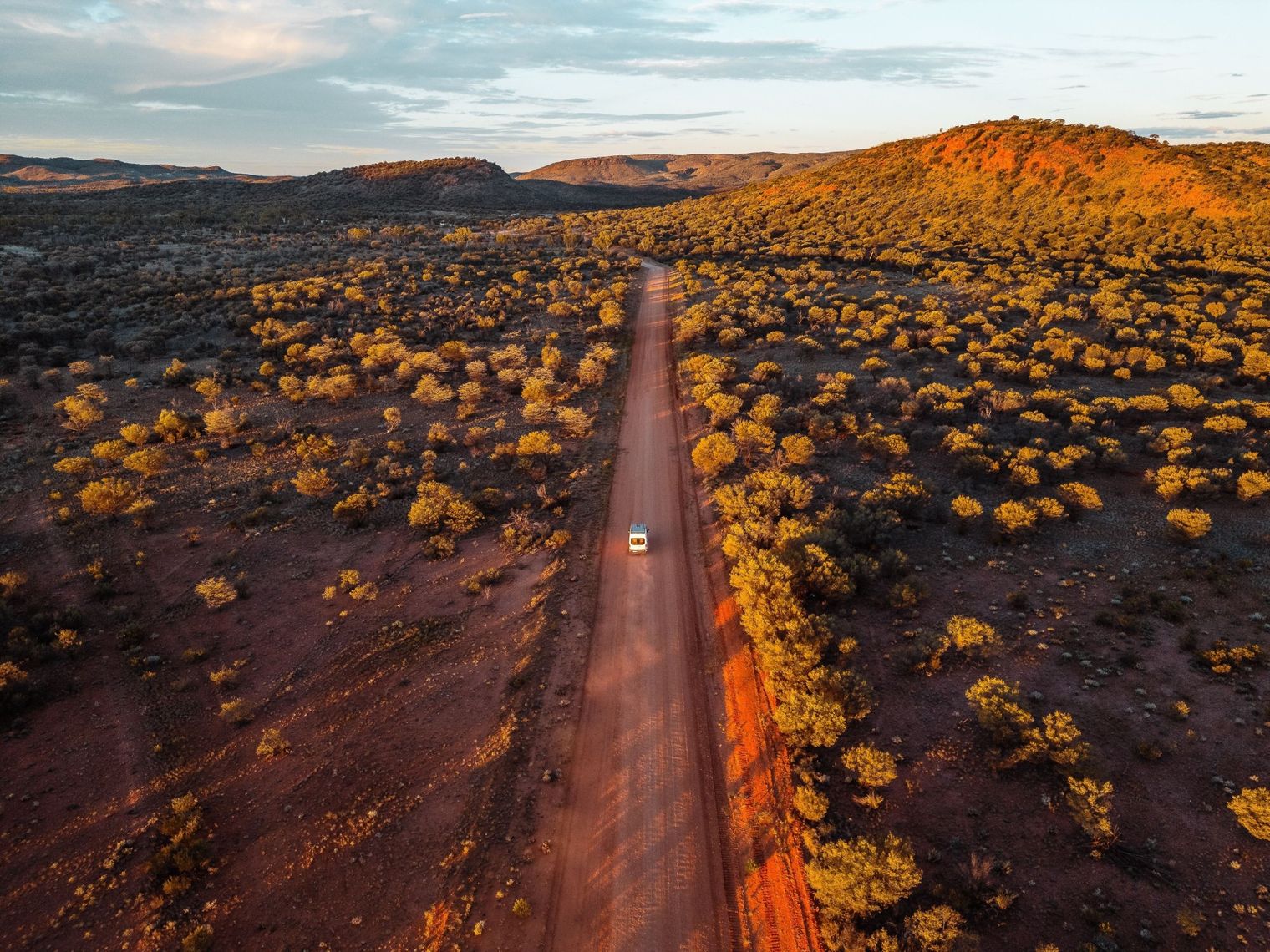 Car driving on a straight road in the Red Centre in Australia.