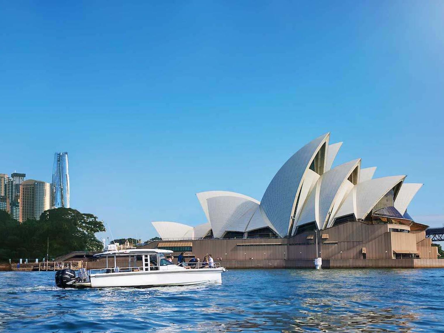 Ein Boot segelt vor dem Opernhaus von Sydney in Australien