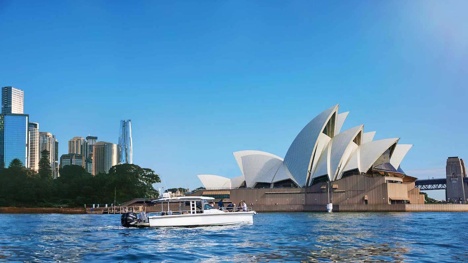 A boat sailing in front of Sydney Opera House in Australia