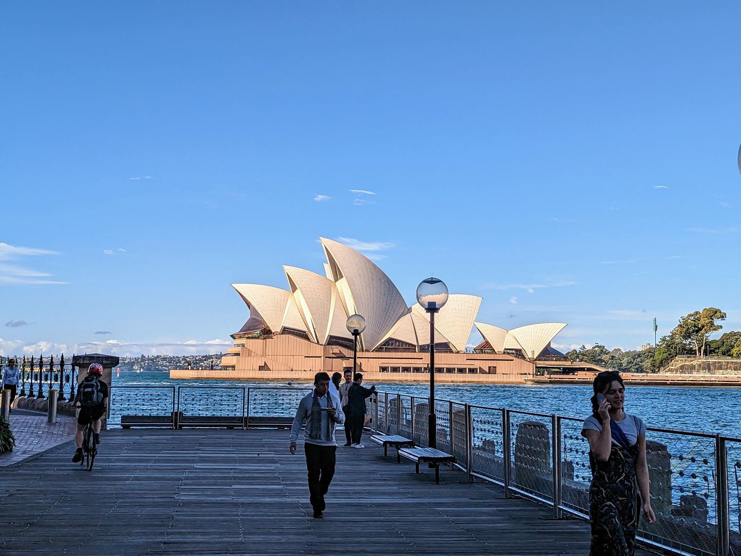 Uitzicht op het Sydney Opera House vanaf een pier waar mensen lopen