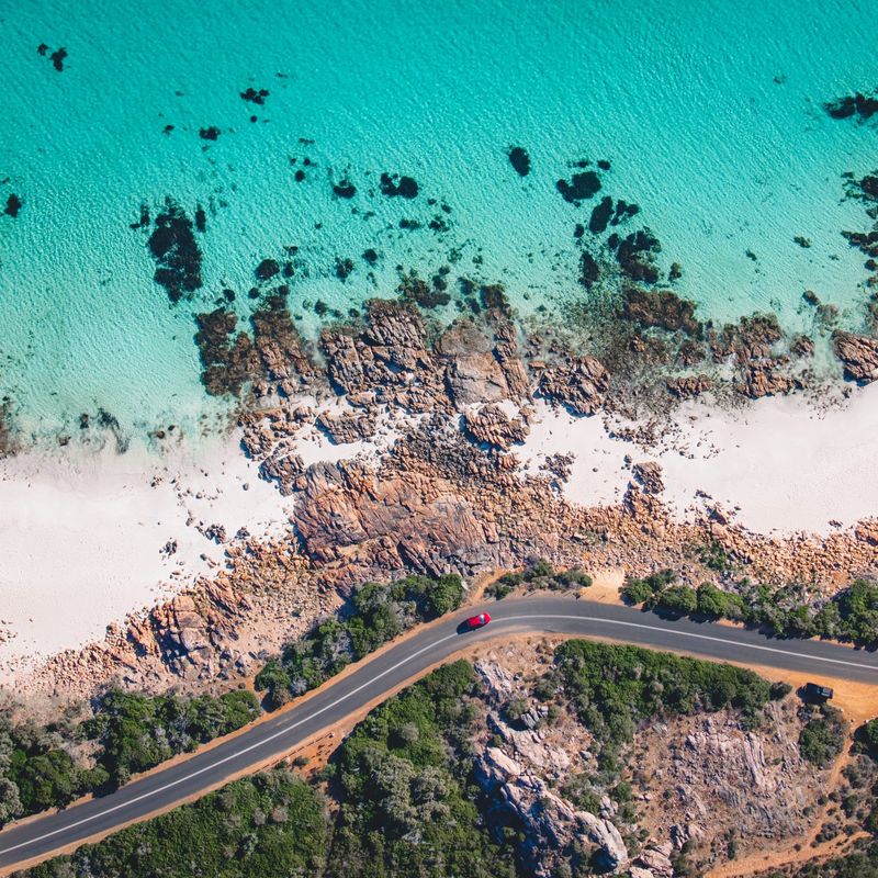 A bird’s-eye view of a road and a rocky coastline with a turquoise sea in Western Australia