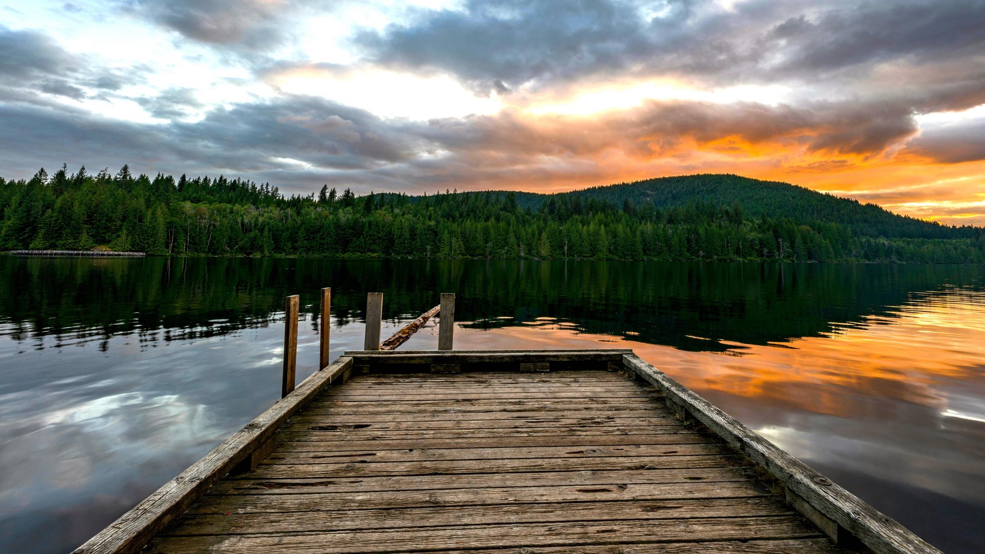 Ein kleiner Holzsteg ragt in den Powell River an der kanadischen Sunshine Coast hinein, während in der Nähe die Sonne untergeht