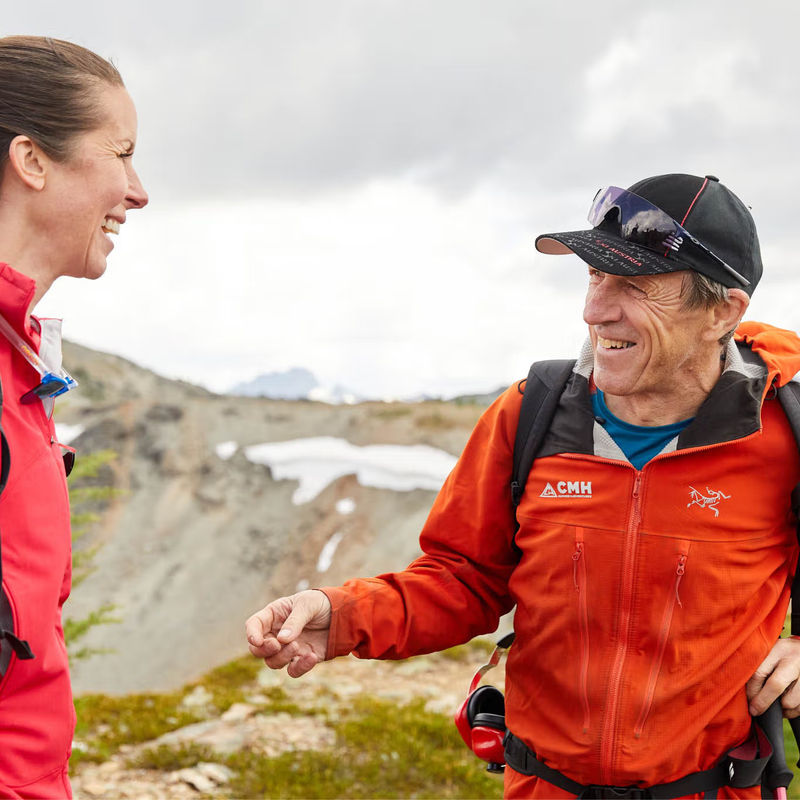 A local guide smiling and talking to a hiker in the mountains of British Columbia