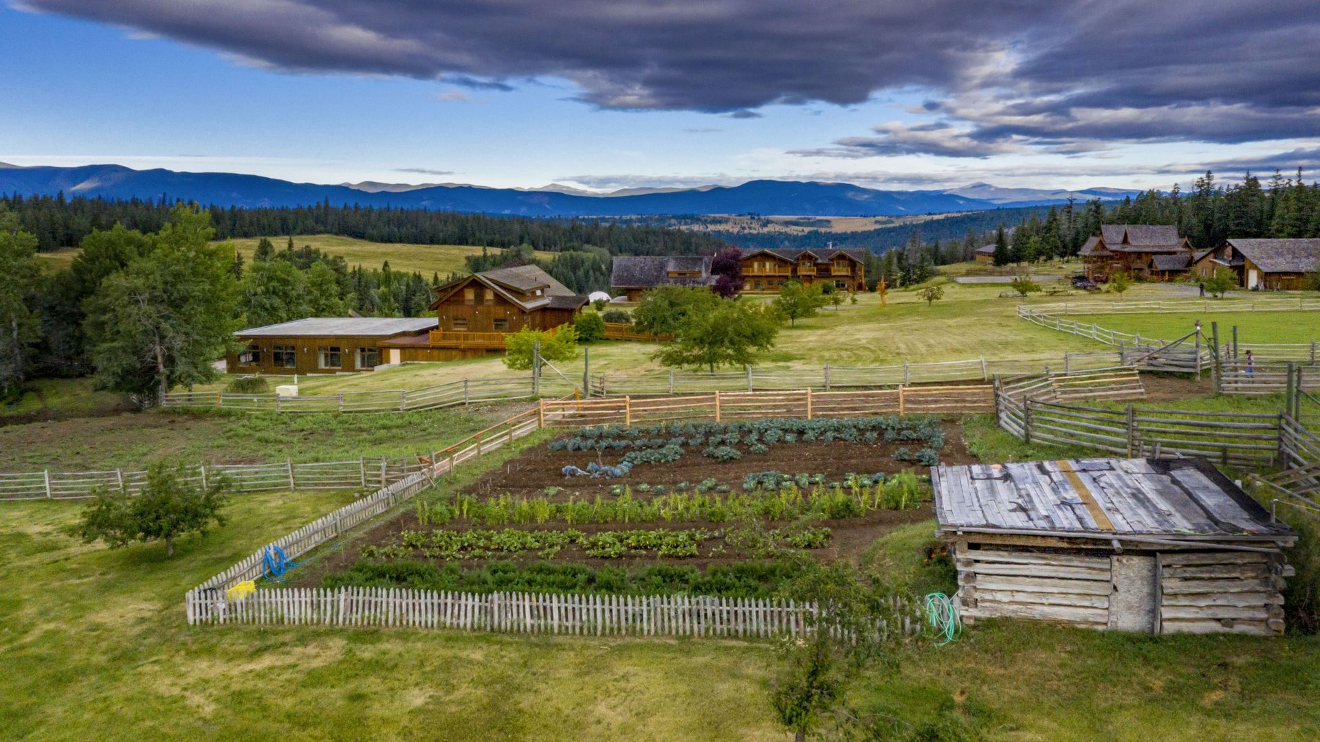 Ranch in Kanada mit Gemüsegarten und bergen im Hintergrund