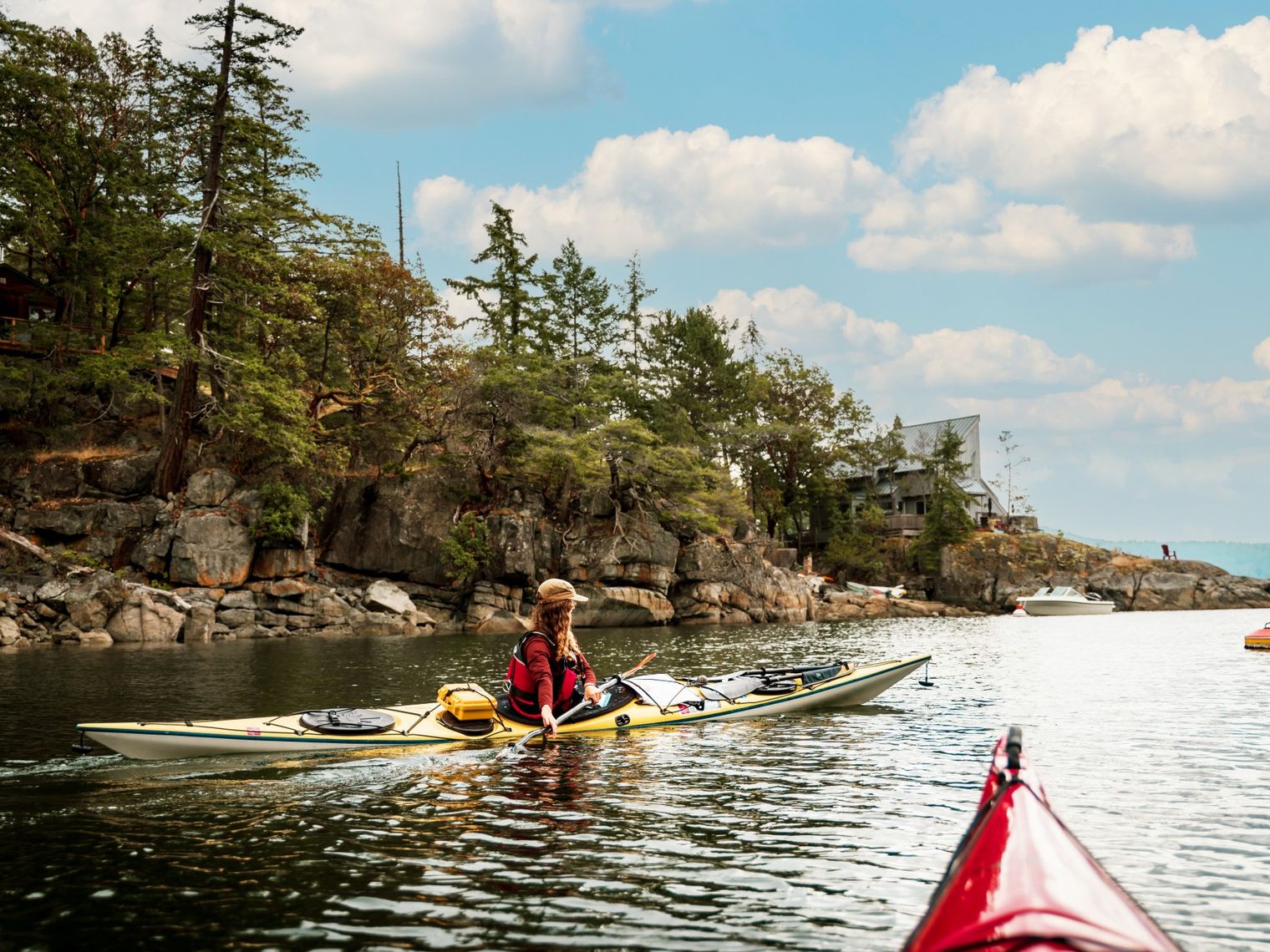 A woman kayaking along the shoreline of sunshine coast