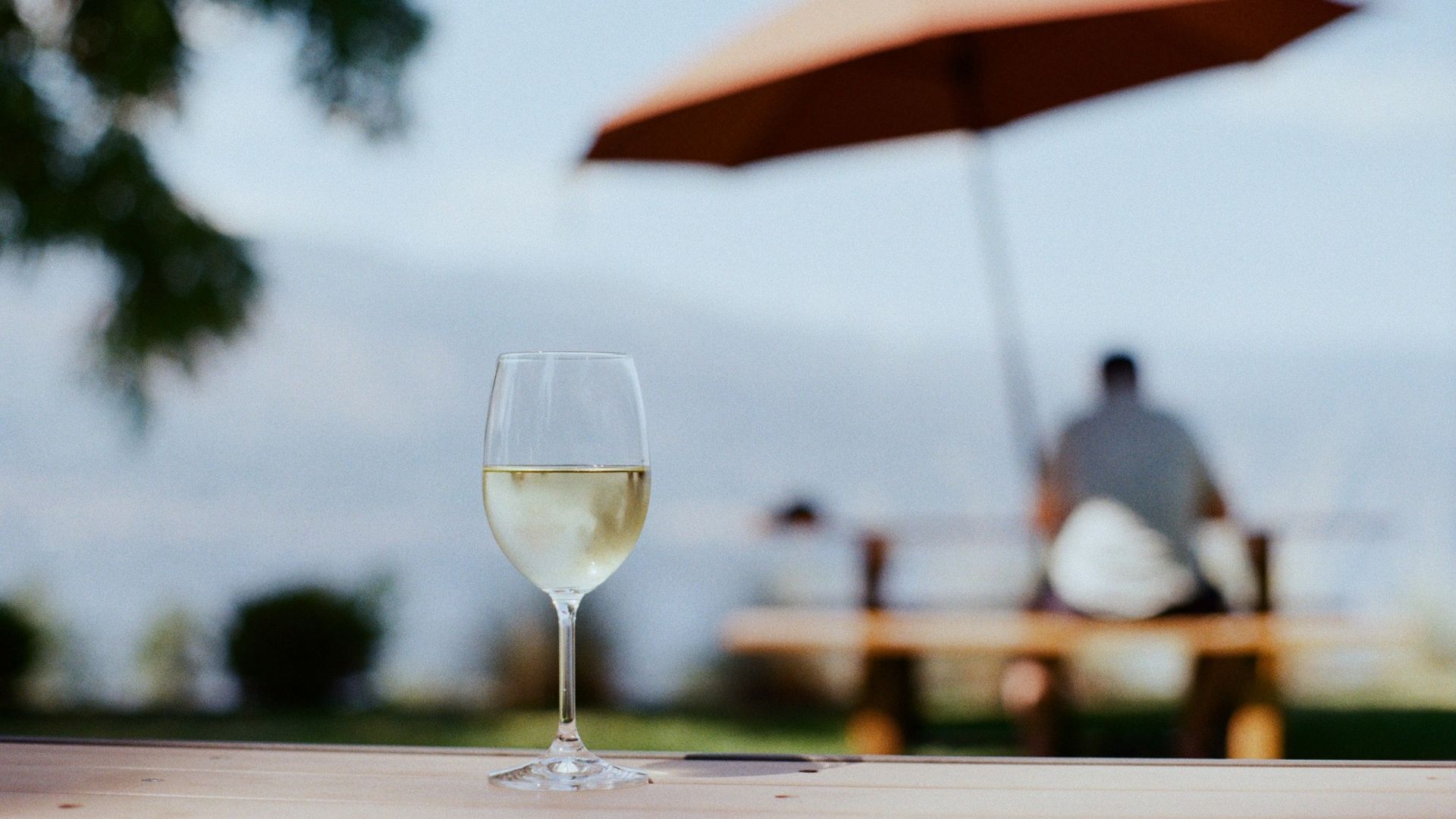 Ein Glas Weißwein auf einem Tisch im Freien