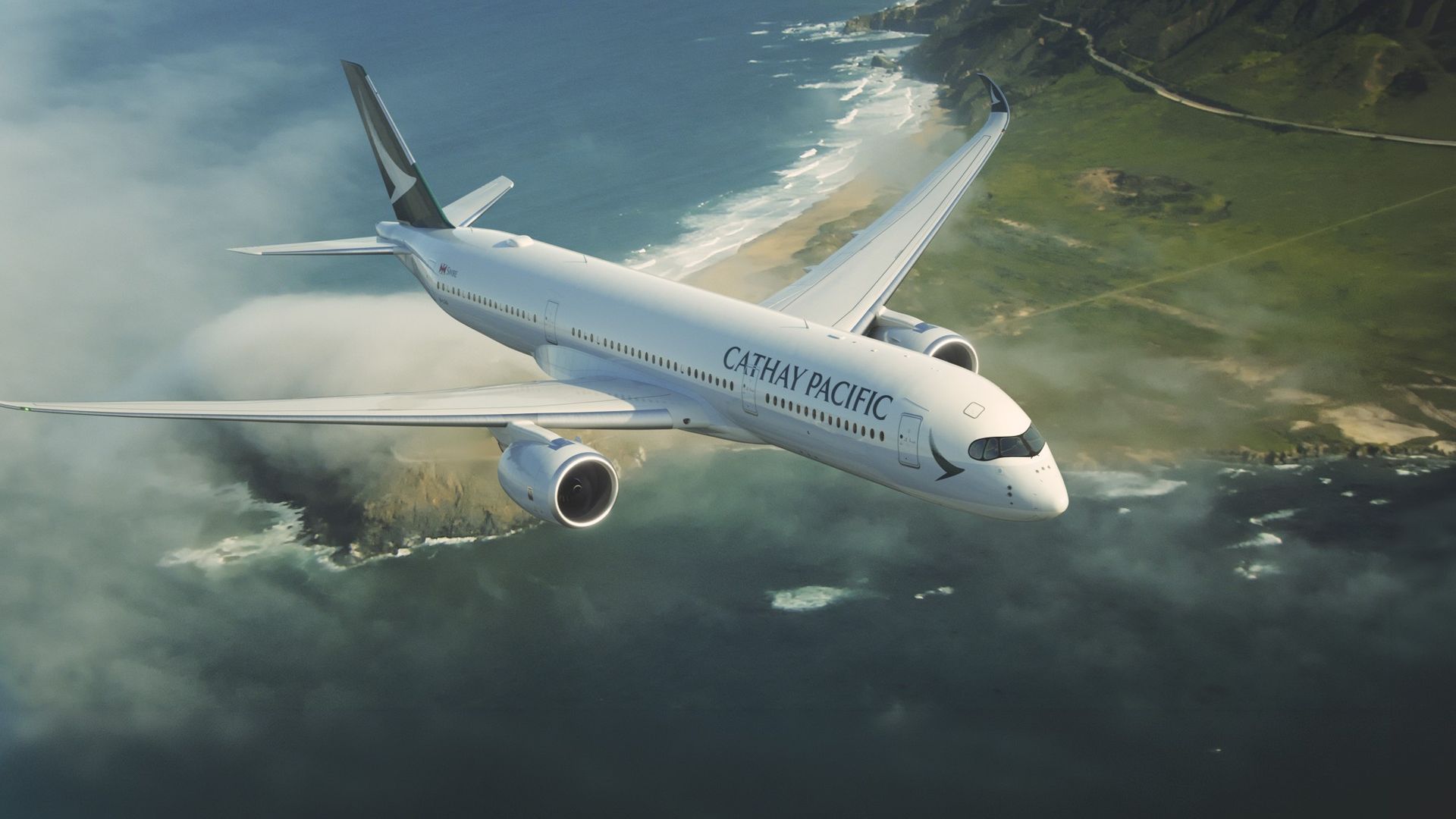 A Cathay Pacific airplane flies over the coastline and sea