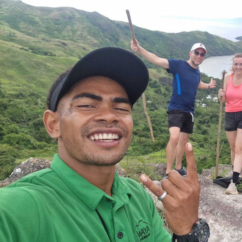 Groep wandelaars nemen een selfie met oceanen en heuvels op de achtergrond in Fiji