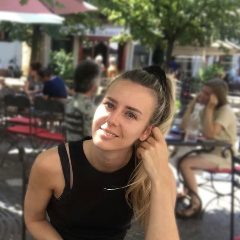 Gerbrich glimlacht naar de camera terwijl hij buiten in een restaurant zit te eten