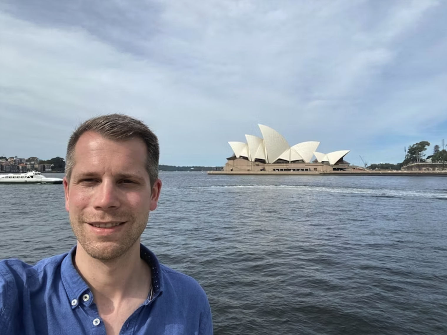 Mann macht Selfie vor dem Opernhaus in Sydney